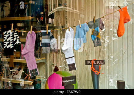 Display of men's colourful socks hang in a shop window. Shop store front. Shopping. Stock Photo