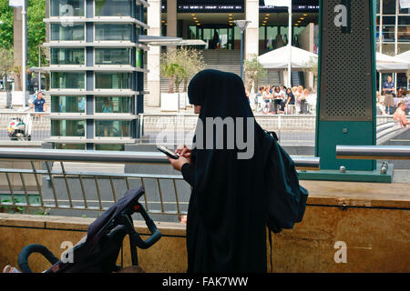 muslim woman wearing burka traditional clothing, using a mobile phone. Shopping mall. Rotterdam, Netherlands, Europe, European Union, EU Stock Photo