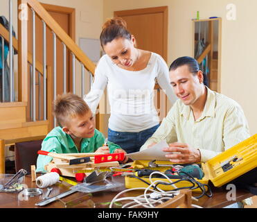 Father and son are doing with their hands crafts in home Stock Photo