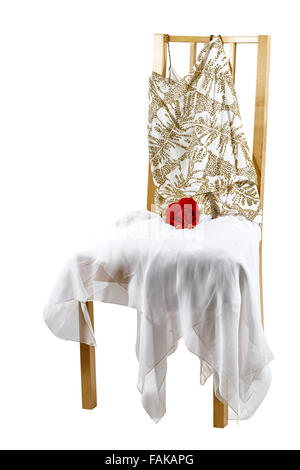 Woman's white evening dress with sequins, rhinestones and a rose draped over a chair isolated on white Stock Photo