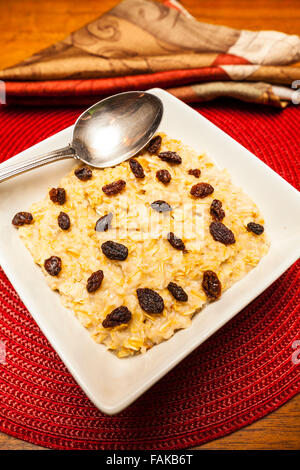 Bowl of oatmeal porridge with raisins on white table Stock Photo - Alamy