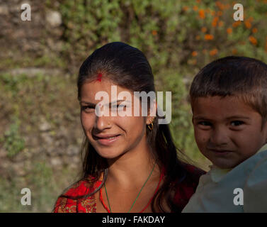 Young Nepalese woman carrying child in the Himalayas. Stock Photo