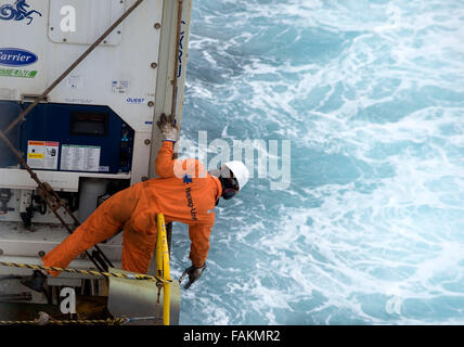 Container ship crew member works on the deck of Utrillo cargo vessel ...