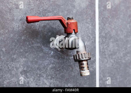 tap and a white line on a concrete wall Stock Photo