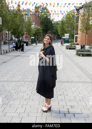 A smiling student at Leeds University in her gown on graduation day. Stock Photo