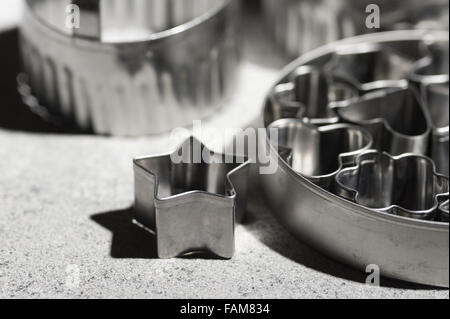 assortment of shiny steel pastry cutters various shapes stars heart playing card emblems biscuit shaping design Stock Photo