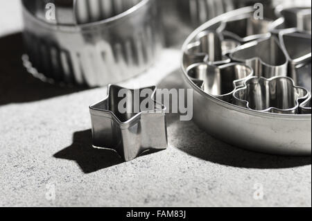 assortment of shiny steel pastry cutters various shapes stars heart playing card emblems biscuit shaping design Stock Photo