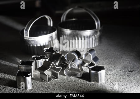 assortment of shiny steel pastry cutters various shapes stars heart playing card emblems biscuit shaping design Stock Photo