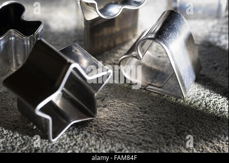 assortment of shiny steel pastry cutters various shapes stars heart playing card emblems biscuit shaping design Stock Photo