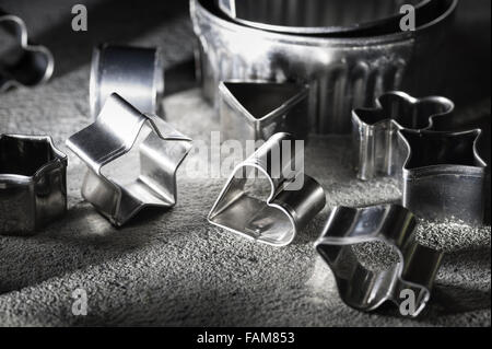 assortment of shiny steel pastry cutters various shapes stars heart playing card emblems biscuit shaping design Stock Photo
