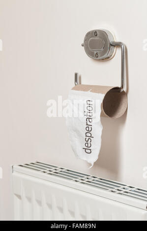 Toilet roll on holder dispenser on pastel painted bathroom wall with last paper tissue left behind asking for trouble Stock Photo