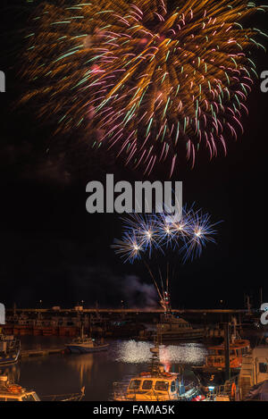 New Year Eve firework display at Ramsgate Royal Harbour with the commercial fleet in the foreground. Stock Photo