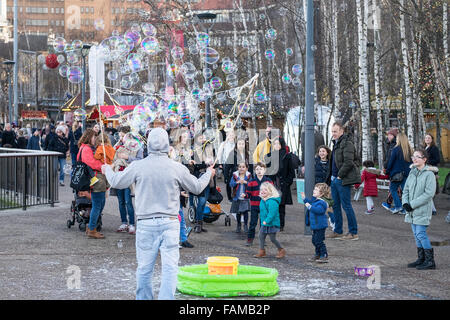 A street entertainer creates bubbles to amuse children and their parents on the South Bank in London. Stock Photo