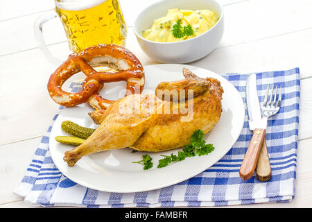 Half roast chicken, beer, pretzel and potato salad, Oktoberfest dinner Stock Photo