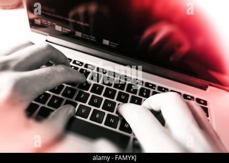 Working on a Laptop. Web Programmer Working on His Laptop Computer Monochrome-Red Color Grading Concept. Stock Photo
