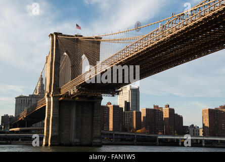 Brooklyn Bridge entering Manhattan with an American flag flying Stock Photo