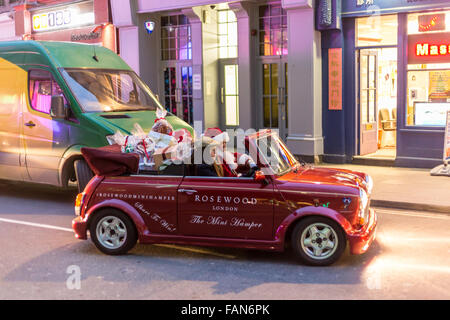 LONDON, UNITED KINGDOM - DECEMBER 03, 2015 - Santa Claus delivering presents to people on the street with a car. Modern Santa concept Stock Photo