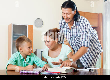 Ordinary family of three doing homework in a home interior Stock Photo