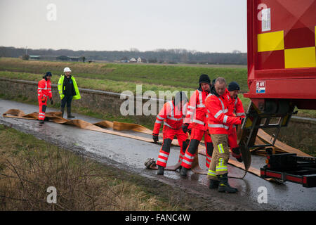 Huge pumps and fire hoses are being used to disperse the flood water left several feet deep in the fields around the flooded Croston village.  Environment Agency workers along with an army of builders and utilities workers are still working to install a temporary bridge to enable them repair the breached river bank. Croston, Lancashire, UK. January, 2016. UK Weather: Stock Photo