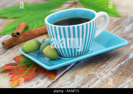 Black coffee in vintage stripy cup and cinnamon sticks on rustic wooden ...