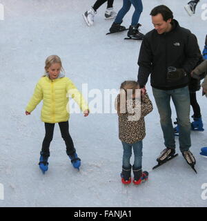 Man and two girls skating at the temporary skating rink on Museumplein (Museum Square), Amsterdam, The Netherlands Stock Photo