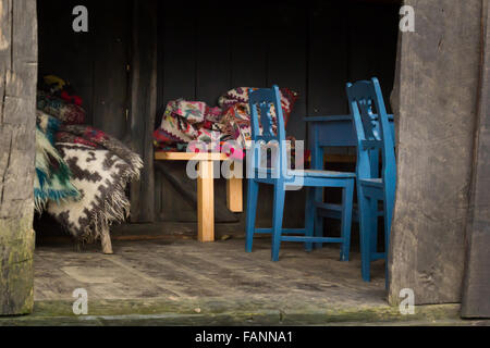 Barn with floral blankets made from wool and blue chairs Stock Photo