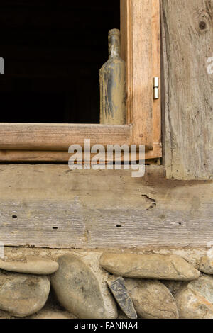 Empty rusty bottle at the frame of a window in an old house Stock Photo