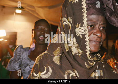 A young Gambian woman emotionally singing during the party in Kololi, The Gambia. Two women on the picture. Stock Photo