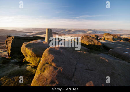 The trig point located at the southern end of Stanage Edge in the Peak District National Park on a cold frosty wintry morning. Stock Photo