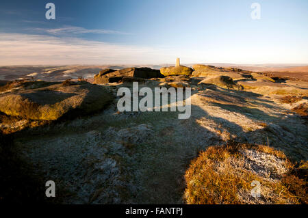 The trig point located at the southern end of Stanage Edge in the Peak District National Park on a cold frosty wintry morning. Stock Photo