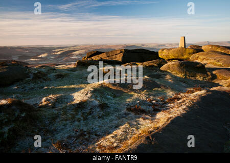 The trig point located at the southern end of Stanage Edge in the Peak District National Park on a cold frosty wintry morning. Stock Photo