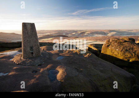 The trig point located at the southern end of Stanage Edge in the Peak District National Park on a cold, frosty wintry morning. Stock Photo