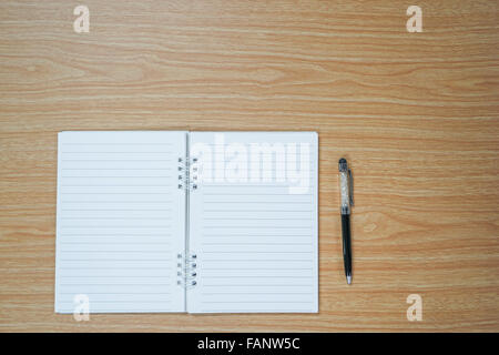 Blank notebook and a pen on wooden table with copyspace Stock Photo