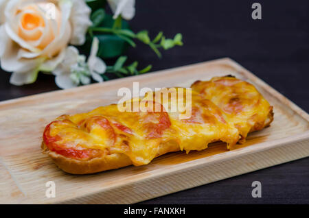 homemade French bread roll, topped with fresh tomatoes, melted cheddar, Mozzarella and Parmesan . Stock Photo