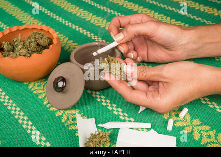 Female hand holding a lit marihuana joint Stock Photo