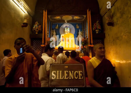 Crowd in queue to offer prayers inside Buddha statue chamber at Mahabodhi Temple, India. Stock Photo