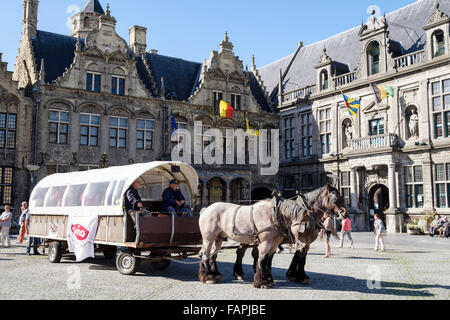 Tourists horse and carriage in town market square with Old Courthouse. Grote Markt, Veurne, West Flanders, Belgium Stock Photo