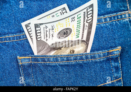 Banknotes of one hundred U. S. dollars bill sticking out of the back jeans pocket Stock Photo