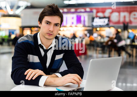 Serious man using portable computer on table Stock Photo