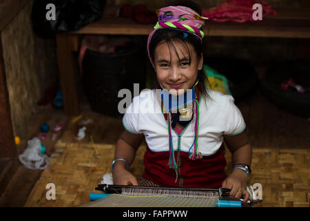 Kayan tribal woman working in a workshop at Inle Lake in Myanmar (Burma). The woman wears brass rings on her neck. Stock Photo