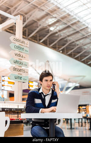 Happy satisfied young man working on laptop Stock Photo