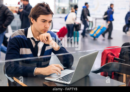 Freelancer working with a laptop in train station Stock Photo