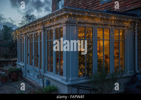 A family enjoying Christmas Day inside a house taken from outside Stock Photo