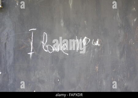 'I Love You' scrawled on black garage door in white chalk. Stock Photo