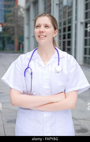 Young Female Nurse With Folded Arms Standing In Hospital Stock