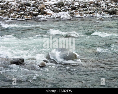 Ice covered rocks in Sandy River with mushroom ice caps Stock Photo