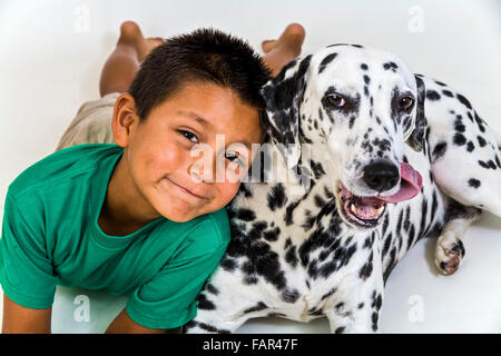 Young Mexican American Hispanic boy wearing green shirt Dalmatian  child playing play plays dog Cut out high above front view MR ©Myrleen Pearson Stock Photo