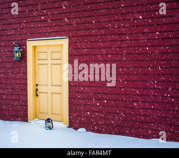 Close up historic red farm house snow storm abstract vintage oil lamp, snow falling, Monmouth County, New Jersey, USA, Farmhouse winter Front door Stock Photo