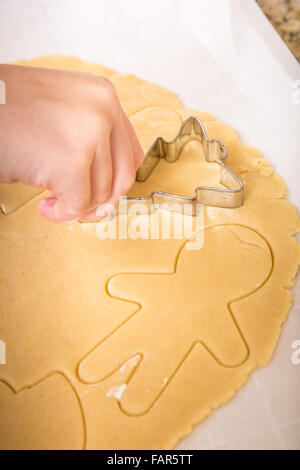 Ten year old girl using cookie cutters to cut out Christmas sugar cookies in Issaquah, Washington, USA Stock Photo