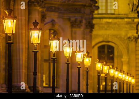 Louvre Museum courtyard with lamps at dusk, Paris Stock Photo